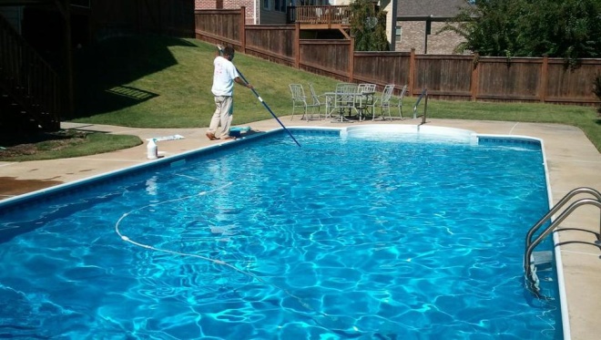 man cleaning pool